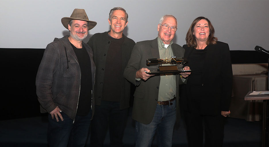 Lucasfilm's Dave Filoni, Josh Lowden, and Lynwen Brennan pose with Ben Burtt, who holds his 50th anniversary golden lightsaber.