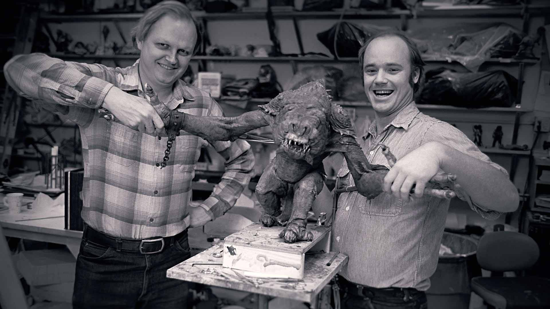 Dennis Muren, left, and Phil Tippett shake hands with their star, a rancor puppet used in Return of the Jedi.